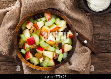 Frische Waldorf Salat, Sellerie, Äpfel, Walnüsse, Sultaninen und Rosinen in Houten mit Mayonnaise auf der Seite, fotografiert Overhead Stockfoto