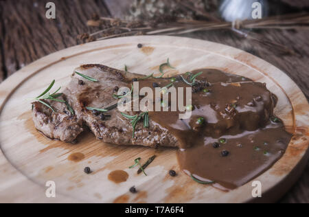 Pfeffer beef steak mit Kräuter und Gewürze gravy Sauce servieren in Holz- Platte. Stockfoto