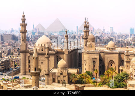 Die Mosque-Madrassa von Sultan Hassan und die Pyramiden im Hintergrund, Kairo, Ägypten. Stockfoto