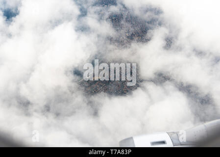 Ein bestimmter Teil der Blick auf die Stadt über den Wolken aus einem Flugzeug. Stockfoto