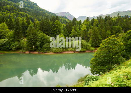 Lac d'Anglus See in Gave d'Aspe Fluss durch Mischwald mit Gabedallos peak am Ende umgeben (Aspe-tal, Pyrénées-Atlantiques, Frankreich) Stockfoto