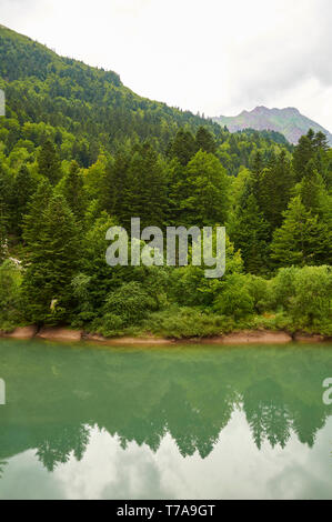 Lac d'Anglus See in Gave d'Aspe Fluss durch Mischwald mit Gabedallos peak am Ende umgeben (Aspe-tal, Pyrénées-Atlantiques, Frankreich) Stockfoto