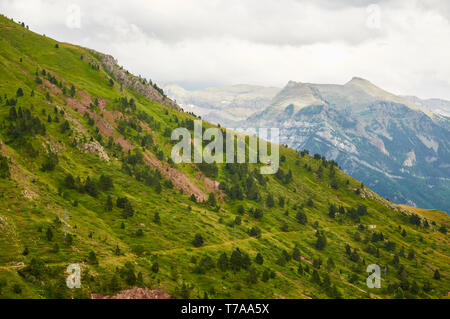 Hügel in der Nähe des Col du Somport Bergpasses mit dem Gipfel La Moleta und dem Kessel Iserías im Hintergrund (Somport, Pyrenäen, Jacetania, Huesca, Aragon, Spanien) Stockfoto