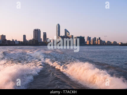 Skyline von London Docklands Canary Wharf vom Boot während der Kreuzfahrt auf der Themse, London, Großbritannien bei Sonnenuntergang gesehen. Stockfoto