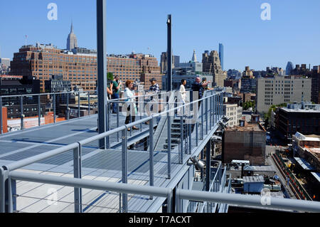 Besucher auf Treppen im Außenbereich und auf der Terrasse des Whitney Museum für amerikanische Kunst mit Meatpacking und Chelsea Bezirk im Hintergrund. New York City, USA. Stockfoto