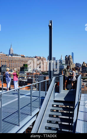 Besucher auf Treppen im Außenbereich und auf der Terrasse des Whitney Museum für amerikanische Kunst mit Meatpacking und Chelsea Bezirk im Hintergrund. New York City, USA. Stockfoto