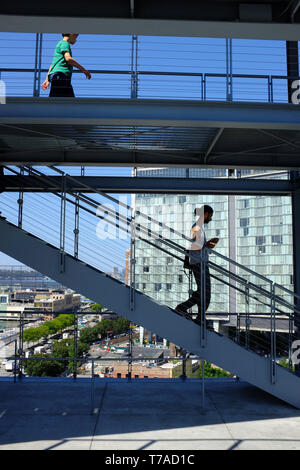 Besucher auf der Treppe der Terrasse des Whitney Museum von Amerika Kunst mit dem Standard Hotel im Meatpacking District im Hintergrund. New York City. Stockfoto