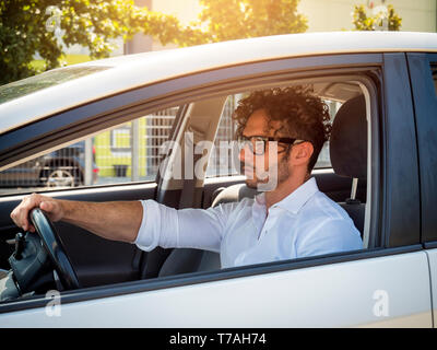 Schöner Mann in seinem Auto sitzen, auf der Suche Stockfoto