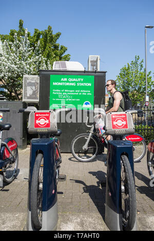 Santander Fahrräder, aka Boris Fahrräder, vor einer Überwachung der Luftqualität in Putney eine von Londons Regionen für die Verschmutzung geparkt. Stockfoto