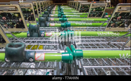 Eine Reihe von gestapelten bargeldloses Waitrose Einkaufswagen außerhalb eines Stores in London geparkt Stockfoto