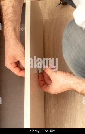 Einbau Türgriffe bei der Montage von Möbeln. Nahaufnahme Stockfoto