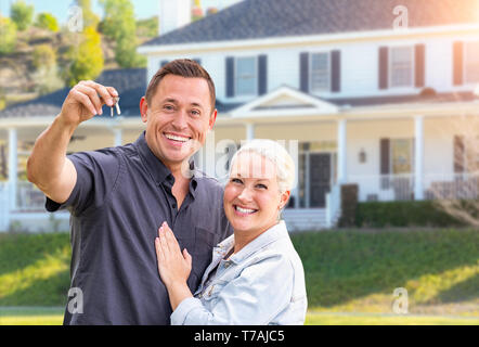 Glückliches Paar mit neuen Haus-Tasten Vor schönes Haus. Stockfoto
