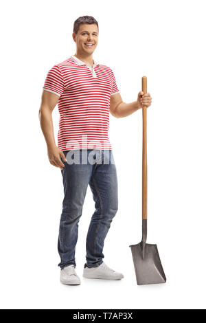 In voller Länge Porträt einer jungen gutaussehenden Mann posiert mit einer Schaufel auf weißem Hintergrund Stockfoto