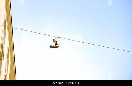 Wien Österreich April 30 2019, alte Schuhe hängen am Draht. Dies ist eine Art von Tradition, Schuhputzmaschine werfen Stockfoto