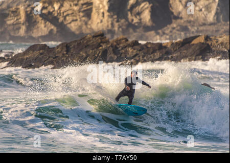 Ein surfer Carving eine Welle an den populären Surfen hotspot Fistral Beach in Newquay in Cornwall. Stockfoto