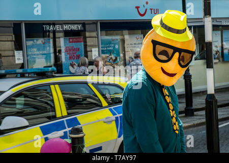 Emoji Mann. Eine Nächstenliebe, die Arbeitnehmer tragen ein großes Smiley falscher Kopf im Stadtzentrum von Truro in Cornwall. Stockfoto