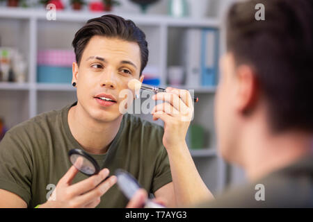 Stilvolle gut aussehender Mann mit gepflegten Haarschnitt während Fertig Stockfoto