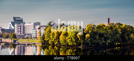 Panoramablick Bahndamm der Stadt Riga im Herbst, üppigen Bäumen wider gespiegelt in Fluss Daugava, blauer Himmel kopieren Platz für Text, sonnigen Tag. Lettland, noch Stockfoto