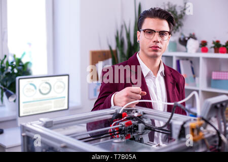 Ernster Mann in klare Brille dunkel rote Jacke und weißes Hemd Stockfoto