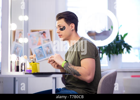 Expressive neugierig Mann sein Blick in den Spiegel Reflexion überprüfen Stockfoto