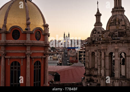 Das Santuario de la Virgen de Guadalupe können zwischen den Kuppeln der Templo del Sagrado Corazon de Jesus oder Tempel der Herz-Jesu-Kirche bei Sonnenaufgang in Jalostotitlan, Jalisco, Mexiko gesehen werden. Stockfoto