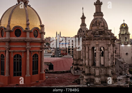 Das Santuario de la Virgen de Guadalupe können zwischen den Kuppeln der Templo del Sagrado Corazon de Jesus oder Tempel der Herz-Jesu-Kirche bei Sonnenaufgang in Jalostotitlan, Jalisco, Mexiko gesehen werden. Stockfoto