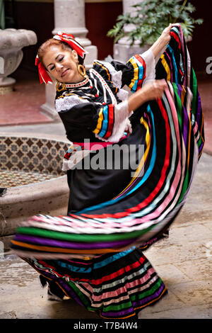 Eine mexikanische Volkstänzer im traditionellen China Poblana Kleid führt die Jarabe folkloristischen Tanz in den Arkaden im Innenhof des Rathauses in Jalostotitlan, Jalisco, Mexiko. Stockfoto