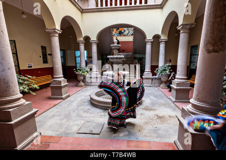 Eine mexikanische Volkstänzer im traditionellen China Poblana Kleid führt die Jarabe folkloristischen Tanz in den Arkaden im Innenhof des Rathauses in Jalostotitlan, Jalisco, Mexiko. Stockfoto