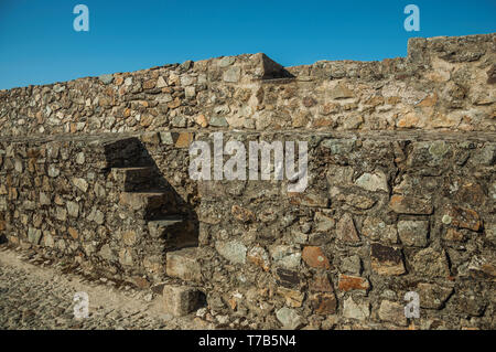 Treppen gehen, weg über eine dicke Wand aus groben Steinen nach Ohrid. Eine mittelalterliche Weiler thront auf einem Felsen in Portugal. Stockfoto