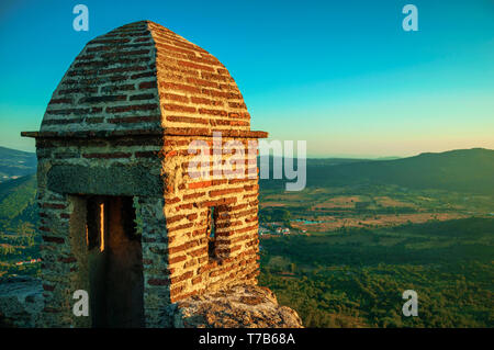 In der Nähe von kleinen Wachturm der Steine über die Klippe mit hügeligen Landschaft auf dem Sonnenuntergang in Ohrid. Eine mittelalterliche Weiler thront auf einem Felsen in Portugal. Stockfoto