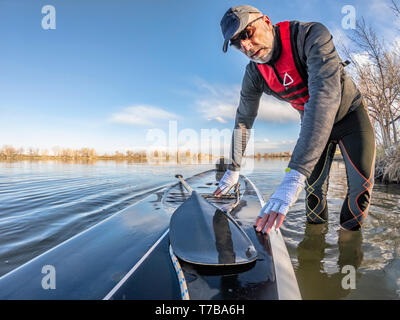 Senior Paddler tragen aufblasbare Rettungsweste und paddeln Handschuhe stößt sein Stand up paddleboard auf einem See, Bild mit Action Kamera Weitwinkel Stockfoto