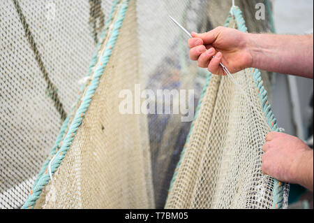 Greetsiel, Deutschland. 02 Mai, 2019. Crab fisherman Florian Zilka Patches die Krabbe Netze auf den Cutter "Flamingo". Da Lager der Großhändler voll sind, Garnelen Fischer in Norddeutschland haben eine Pause zu nehmen. Für die Fischer Dies ist eine finanzielle Gefahr (dpa' crab Fisherman: "Es gibt nichts, das am Ende des Monats') Credit Links: mohssen Assanimoghaddam/dpa/Alamy leben Nachrichten Stockfoto