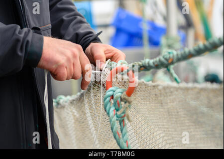 Greetsiel, Deutschland. 02 Mai, 2019. Crab fisherman Florian Zilka Patches die Krabbe Netze auf den Cutter "Flamingo". Da Lager der Großhändler voll sind, Garnelen Fischer in Norddeutschland haben eine Pause zu nehmen. Für die Fischer Dies ist eine finanzielle Gefahr (dpa' crab Fisherman: "Es gibt nichts, das am Ende des Monats') Credit Links: mohssen Assanimoghaddam/dpa/Alamy leben Nachrichten Stockfoto