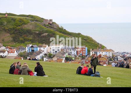 Hastings, East Sussex, UK. 06. Mai 2019. UK Wetter: ein helles, aber kalten Nachmittag, als das Wetter nimmt eine Umdrehung für das schlechtere in Hastings, East Sussex. Die Leute sitzen im Gras auf West Hill Cliff genießen die Mayday Bank Holiday. © Paul Lawrenson 2019, Foto: Paul Lawrenson/Alamy leben Nachrichten Stockfoto