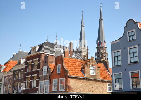 Traditionelle und bunte Fassaden auf dem Hauptplatz (Markt) mit den Spitzen der Maria van Jesse Kerk im Hintergrund, Delft, Niederlande Stockfoto