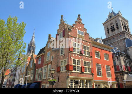 Traditionelle und bunte Fassaden mit Nieuwe Kerk Clock Tower im Hintergrund und das Rathaus (Stadhuis) auf der rechten Seite, Delft, Niederlande Stockfoto