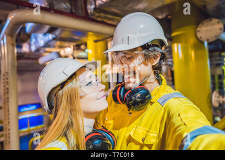 Der Mann und die Frau in einem gelben Arbeiten einheitliche, Gläser, und Helm im industriellen Umfeld, Öl Plattform oder verflüssigte Gas-Anlage Stockfoto