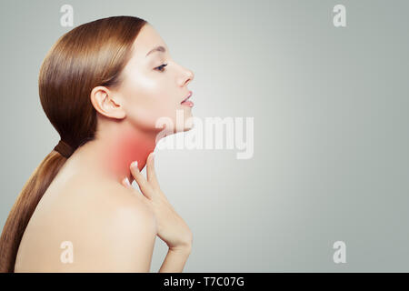 Junge Frau mit Halsschmerzen. Frau legt die Hände auf den Hals Stockfoto