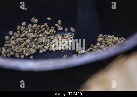 Nahaufnahme der grünen Kaffeebohnen in einem Topf auf dem Feuer. Rösten von Kaffee lecker aromatische Getränk zu machen. Gerne morgen in Afrika. Stockfoto