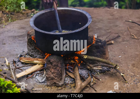 Heiße rote Flamme des Feuer, schwelbrand Brennholz, Natur um. Frische Luft der Berge in einem Dorf. Lecker Rauch mit gerösteten Kaffee Aroma. Stockfoto