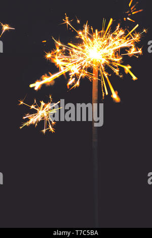 Brennende Wunderkerze auf dunklem Hintergrund. Neues Jahr funkelt Leuchten mit Kopie Raum Stockfoto