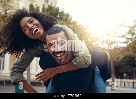 Mann seine Freundin piggyback Ride geben Stockfoto