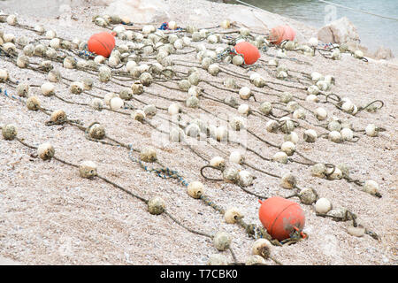 Bojen auf Seilen an der Küste Strand gesäumt und bereit, in Meerwasser zu Beginn der Badesaison. Stockfoto