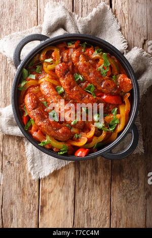 Italienisches Essen Bratwurst mit gegrillten Paprika, Zwiebeln, Kräuter und Tomaten in einer Pfanne closeup Pfanne auf dem Tisch. Vertikal oben Ansicht von oben Stockfoto