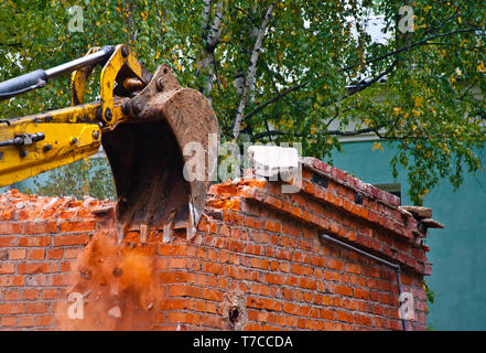 Gebäudeabbruch mit leistungsfähiger Hydraulikbagger Stockfoto