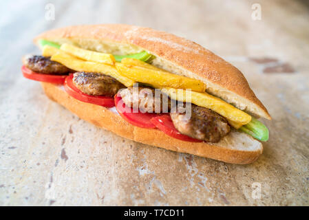 Hausgemachte schmackhaft und lecker würzigen Fleischbällchen in der Sandwich mit Tomate, Bratkartoffeln und grünem Pfeffer. traditionellen türkischen Kebab Stockfoto