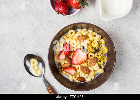 Schüssel mit Müsli Ringe cheerios, Erdbeeren und Milch. Das traditionelle Frühstück Konzept. Stockfoto