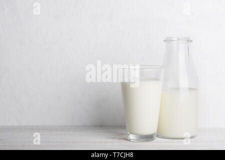 Flasche und Glas Milch auf weissem Holztisch Stillleben mit Kopie Raum Stockfoto
