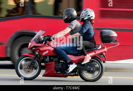 Belgrad, Serbien - April 26, 2019: Paar reiten auf einem roten Motorrad in der Stadt Straße Verkehr Stockfoto