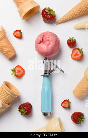 Strawberry Ice Cream scoop Löffel mit wafer Kegel und Beeren auf weißen Tisch flatlay Stockfoto